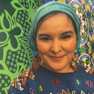 woman's portrait with headscarf in front of colorful mural