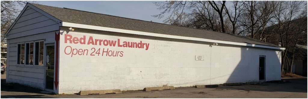 long blank wall for mural, words "red arrow laundry open 24 hours"